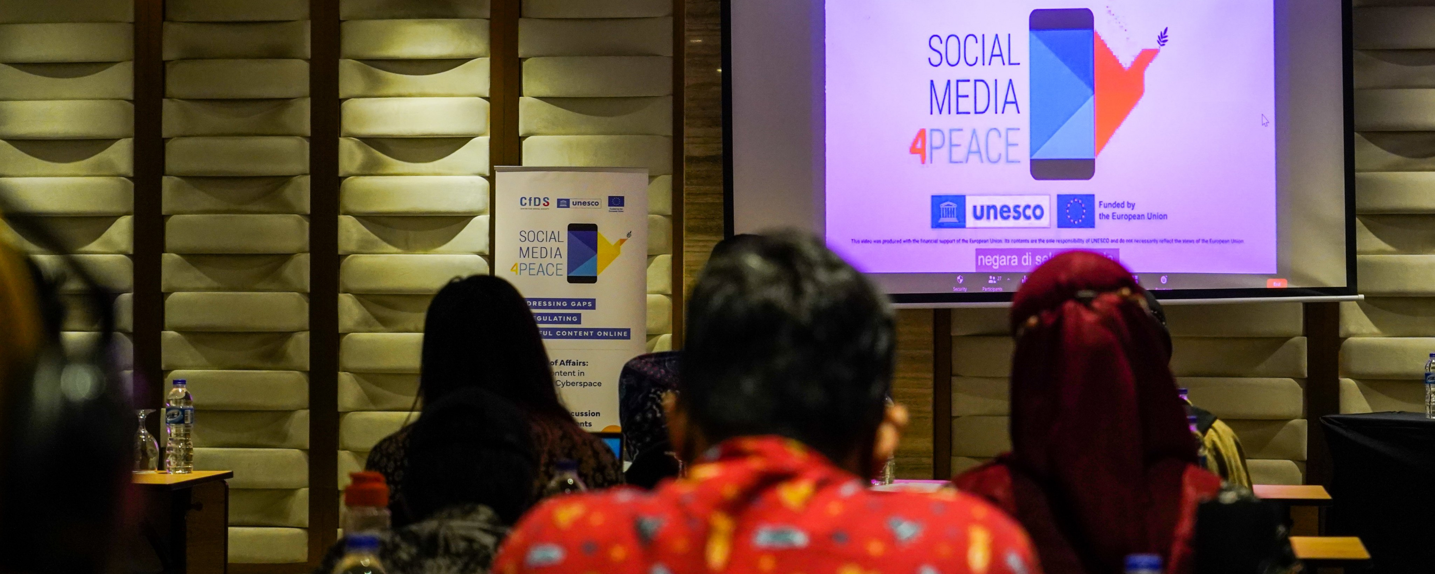 Group of seated person looking at Social Media 4 Peace conference presentation