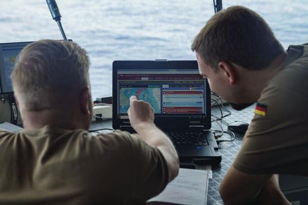 German navy inspect data on a computer screen.